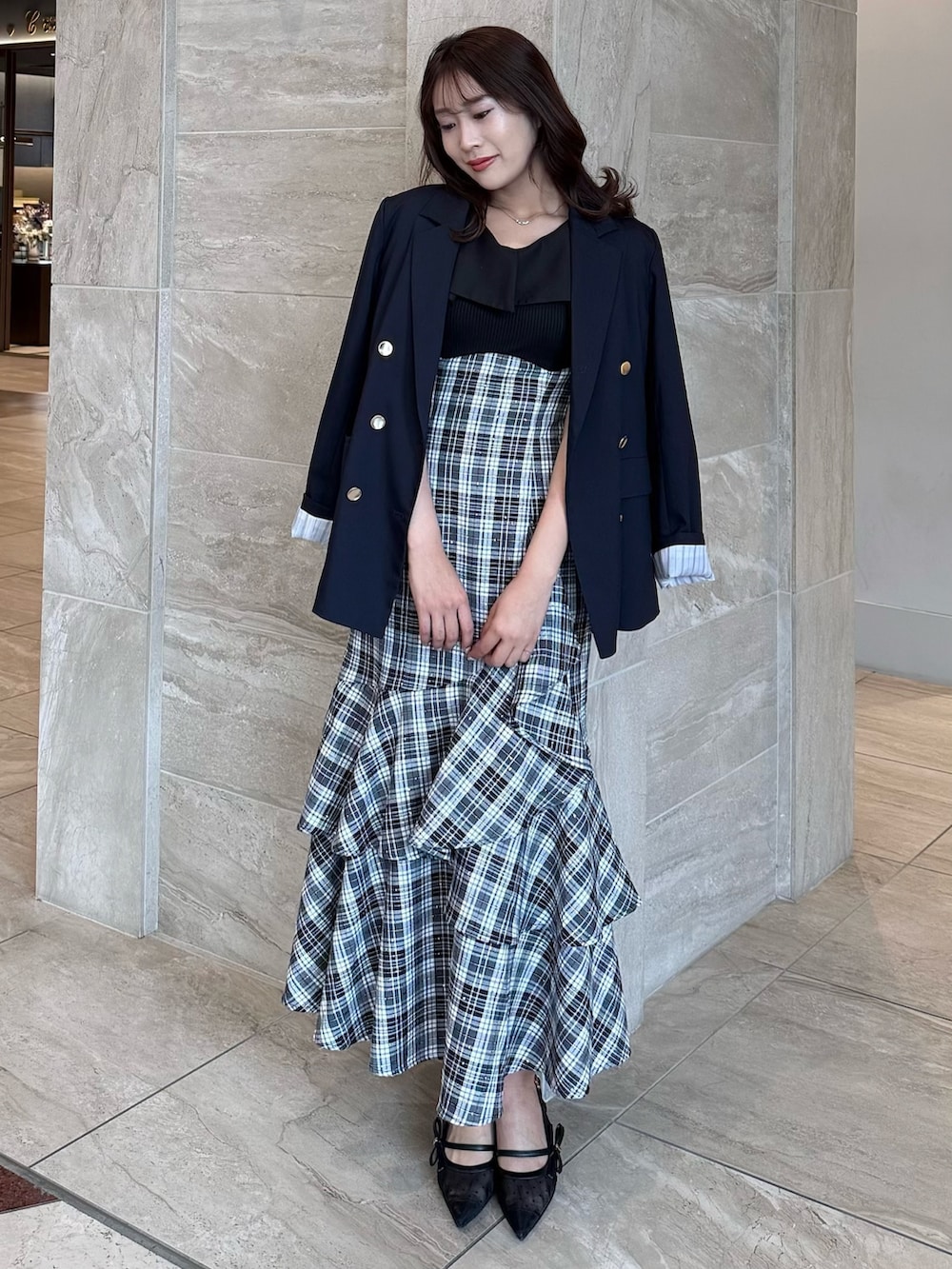 ブルー系のテーラードジャケット、ブラック系のワンピース、ブラック系のパンプスを着用したレディースの春コーディネートの4枚目の写真