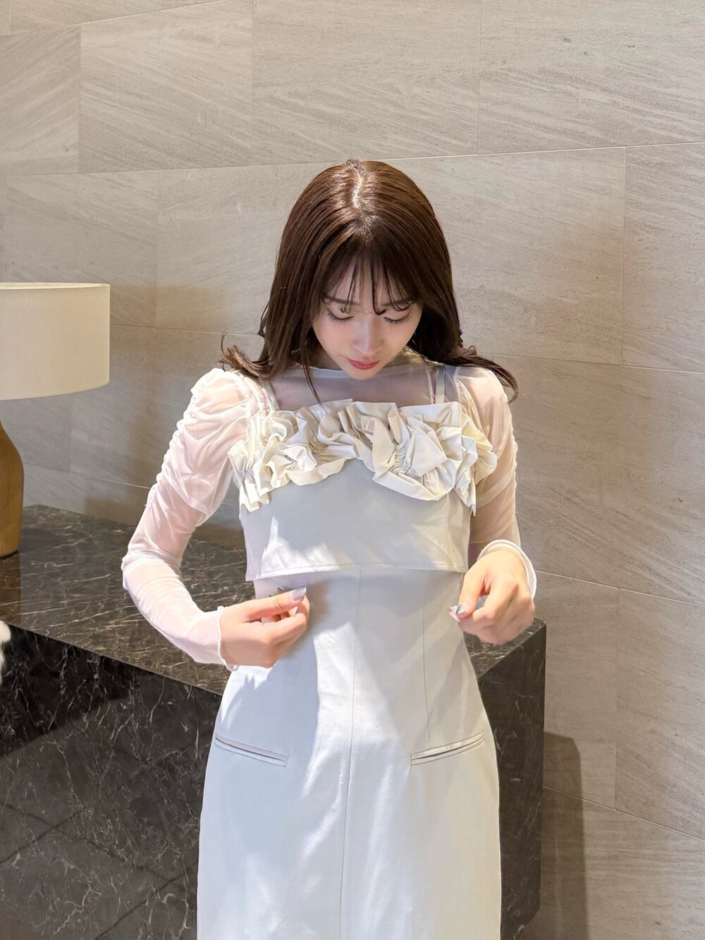 ベージュ系のワンピース、ホワイト系のTシャツ/カットソー、ブラウン系のローファーを着用したレディースの春コーディネートの7枚目の写真
