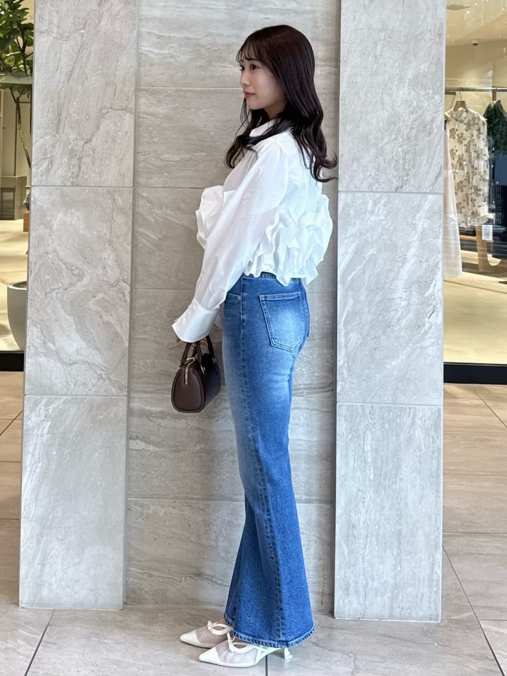 ホワイト系のシャツ/ブラウス、ブルー系のデニムパンツ、ホワイト系のパンプスを着用したレディースの春コーディネートの4枚目の写真