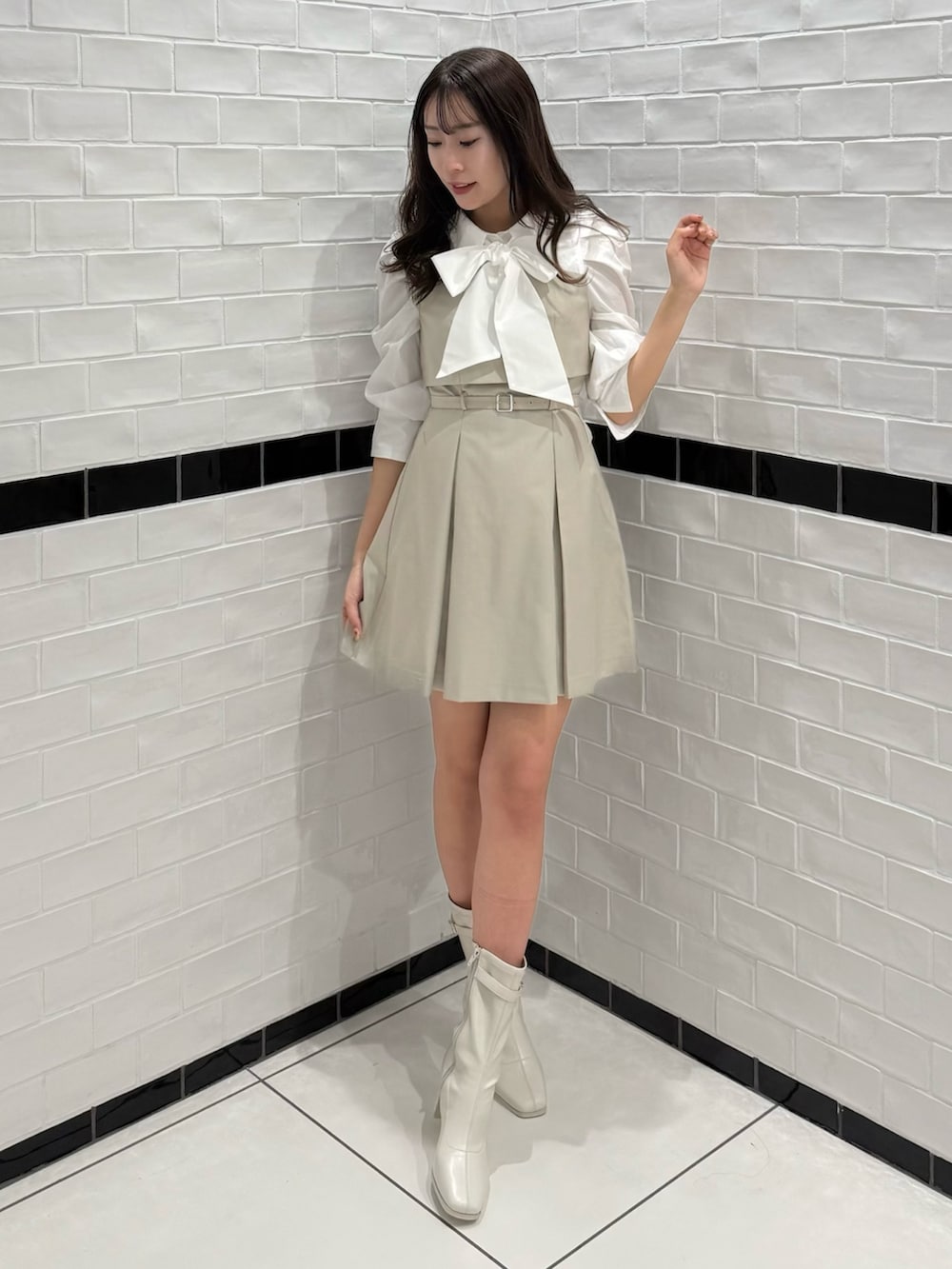 ベージュ系のワンピース、ホワイト系のブーツを着用したレディースの春コーディネートの4枚目の写真