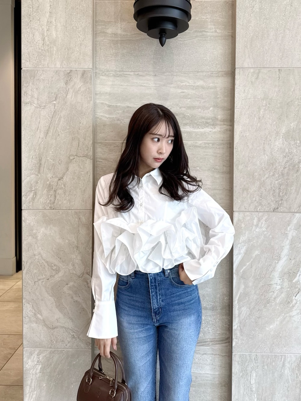 ホワイト系のシャツ/ブラウス、ブルー系のデニムパンツ、ホワイト系のパンプスを着用したレディースの春コーディネートの6枚目の写真