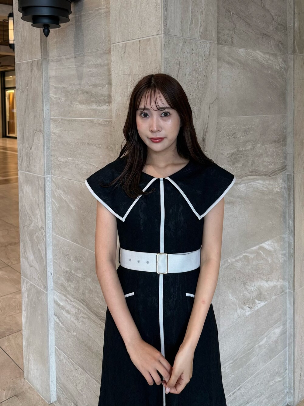 ブラック系のワンピース、ブラック系のパンプスを着用したレディースの夏コーディネートの6枚目の写真