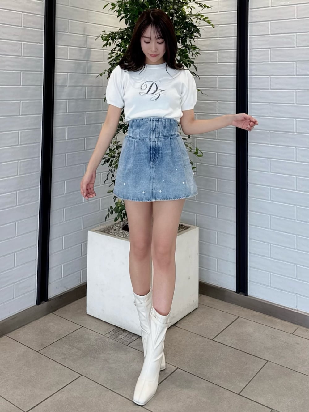 ホワイト系のニット/セーター、ブルー系のデニムパンツ、ホワイト系のブーツを着用したレディースの春コーディネートの7枚目の写真