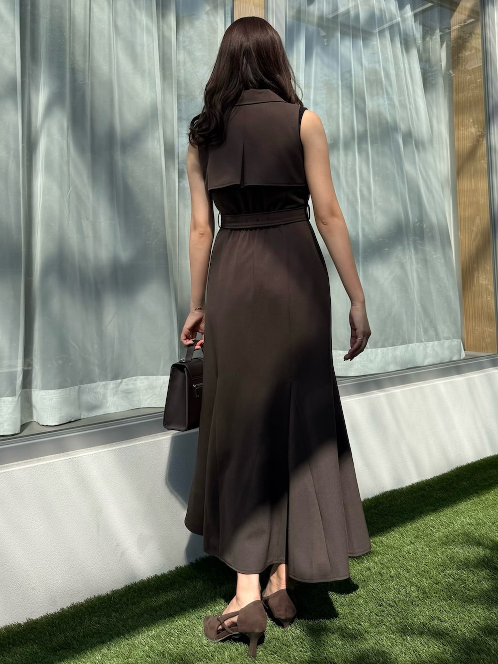 ブラウン系のワンピース、ブラウン系のショルダーバッグ、ブラウン系のパンプスを着用したレディースの秋コーディネートの5枚目の写真