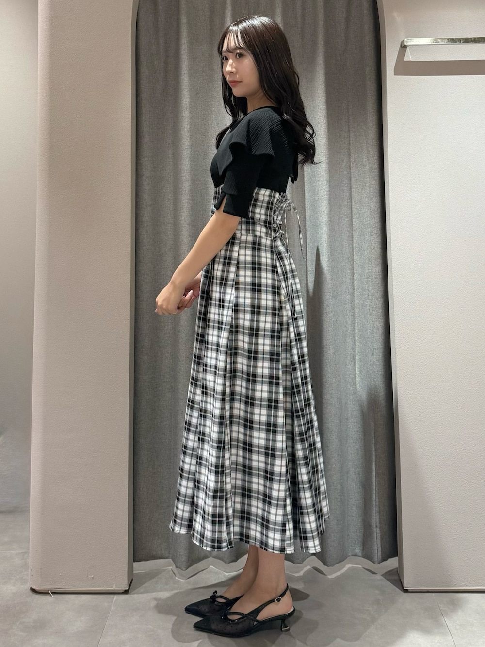 ブラック系のワンピース、ブラック系のパンプスを着用したレディースの春コーディネートの5枚目の写真