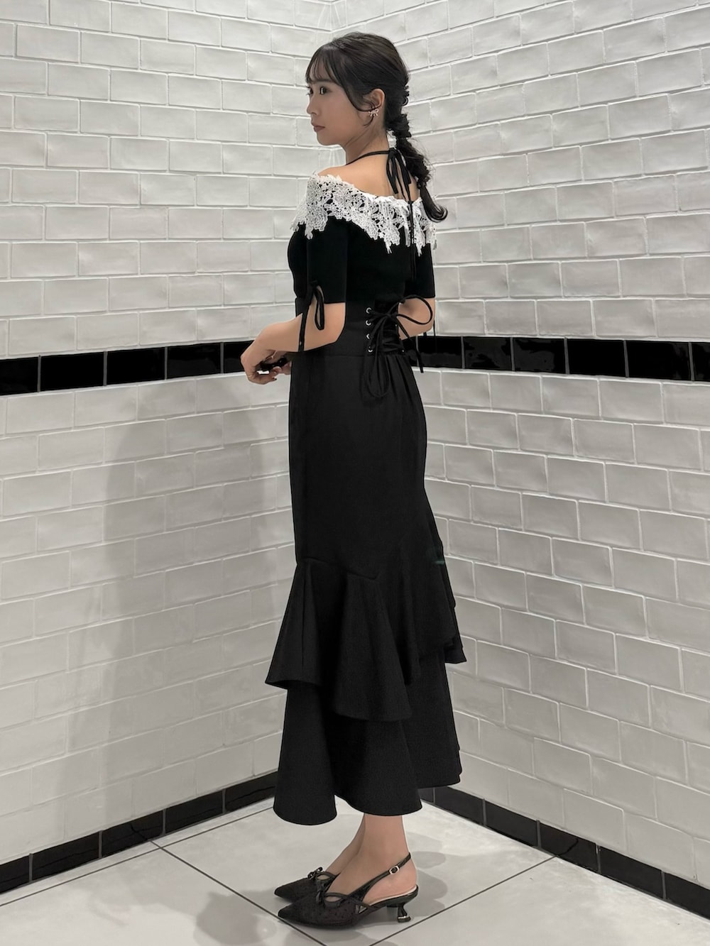 ブラック系のニット/セーター、ブラック系のスカート、ブラック系のパンプスを着用したレディースの春コーディネートの7枚目の写真