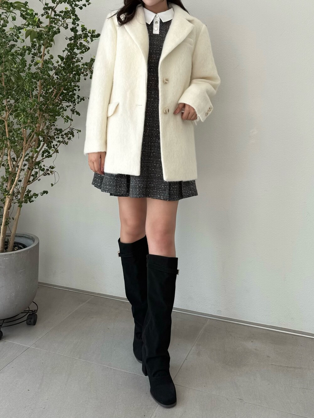 ホワイト系のテーラードジャケット、グレー系のワンピース、ブラック系のブーツを着用したレディースの秋コーディネートの4枚目の写真