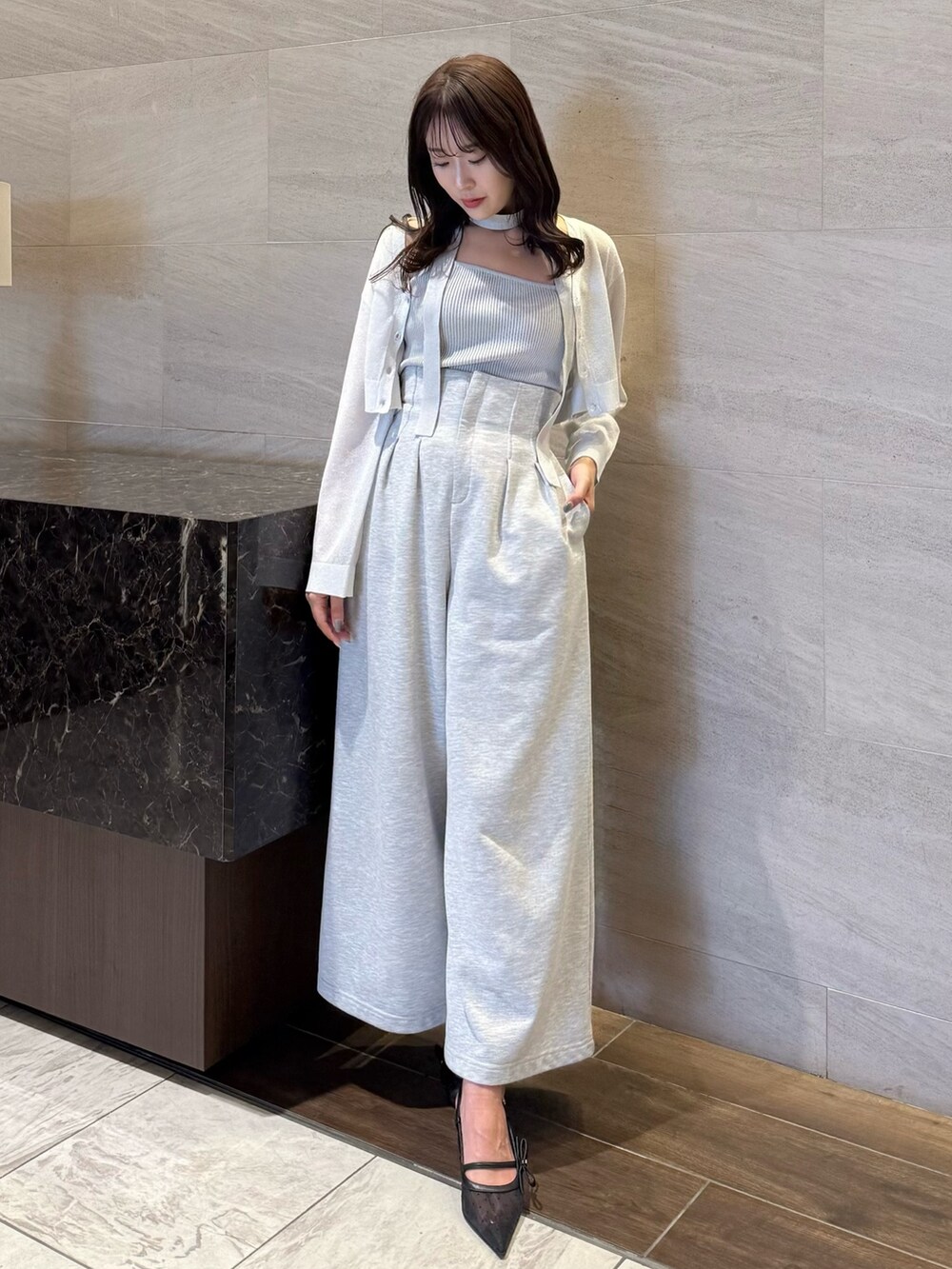 グレー系のニット/セーター、グレー系のその他パンツ、ブラック系のパンプスを着用したレディースの春コーディネートの5枚目の写真