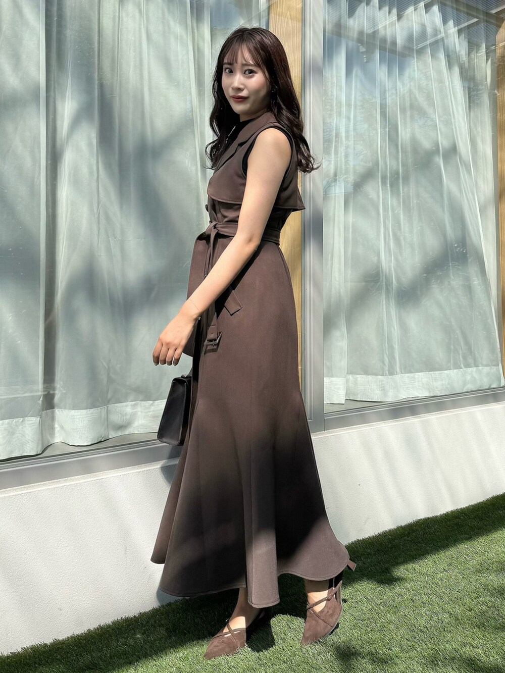 ブラウン系のワンピース、ブラウン系のショルダーバッグ、ブラウン系のパンプスを着用したレディースの秋コーディネートの3枚目の写真