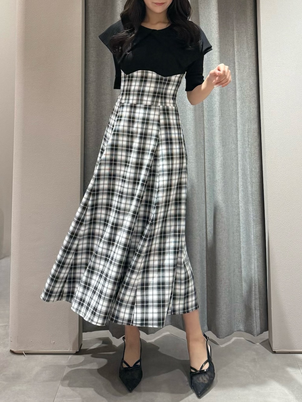 ブラック系のワンピース、ブラック系のパンプスを着用したレディースの春コーディネートの4枚目の写真