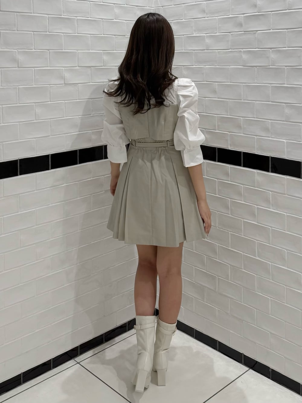 ベージュ系のワンピース、ホワイト系のブーツを着用したレディースの春コーディネートの7枚目の写真