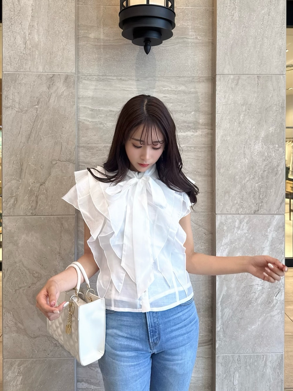 ホワイト系のシャツ/ブラウス、ブルー系のデニムパンツ、ホワイト系のサンダルを着用したレディースの春コーディネートの6枚目の写真