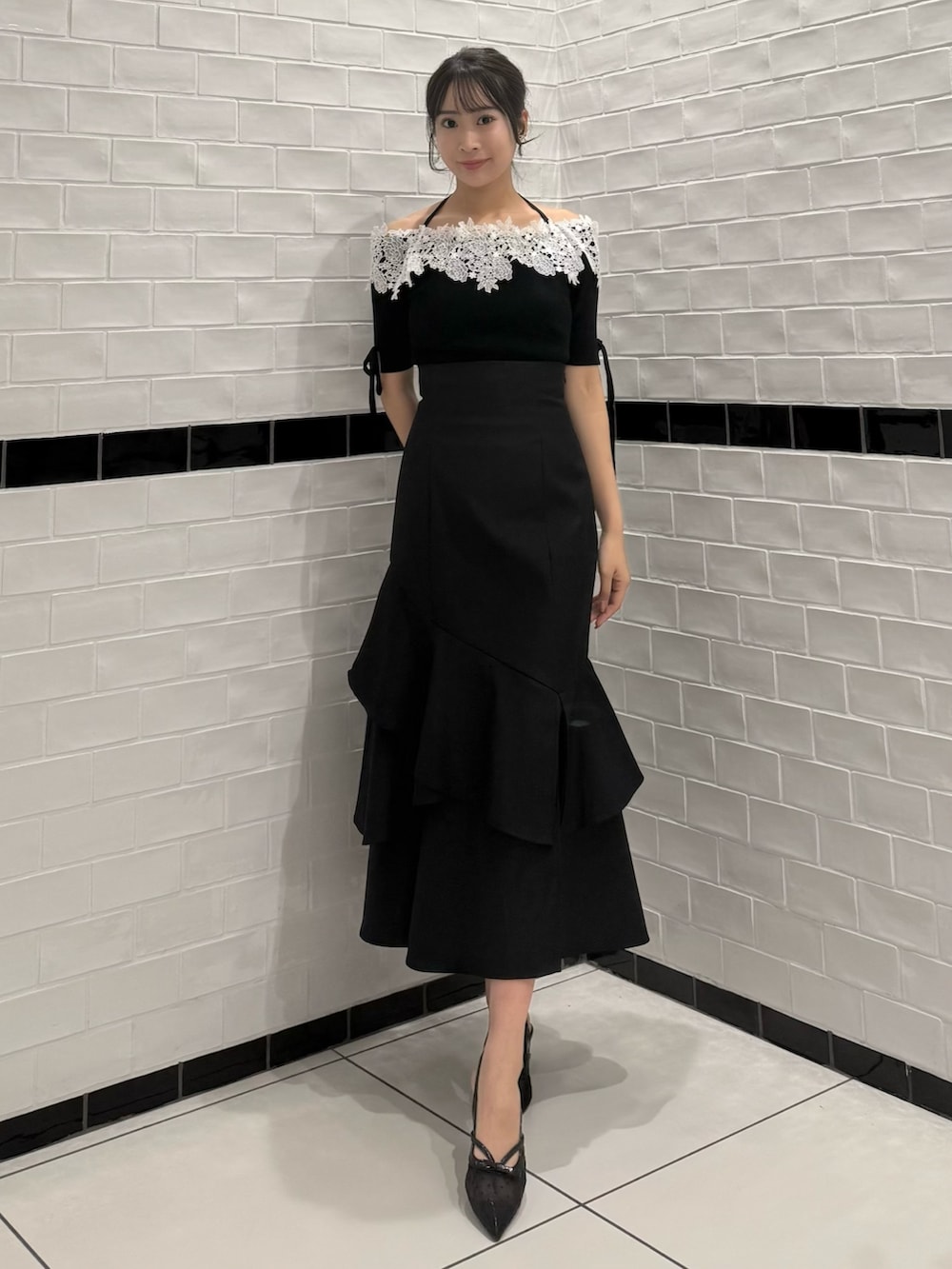 ブラック系のニット/セーター、ブラック系のスカート、ブラック系のパンプスを着用したレディースの春コーディネートの3枚目の写真