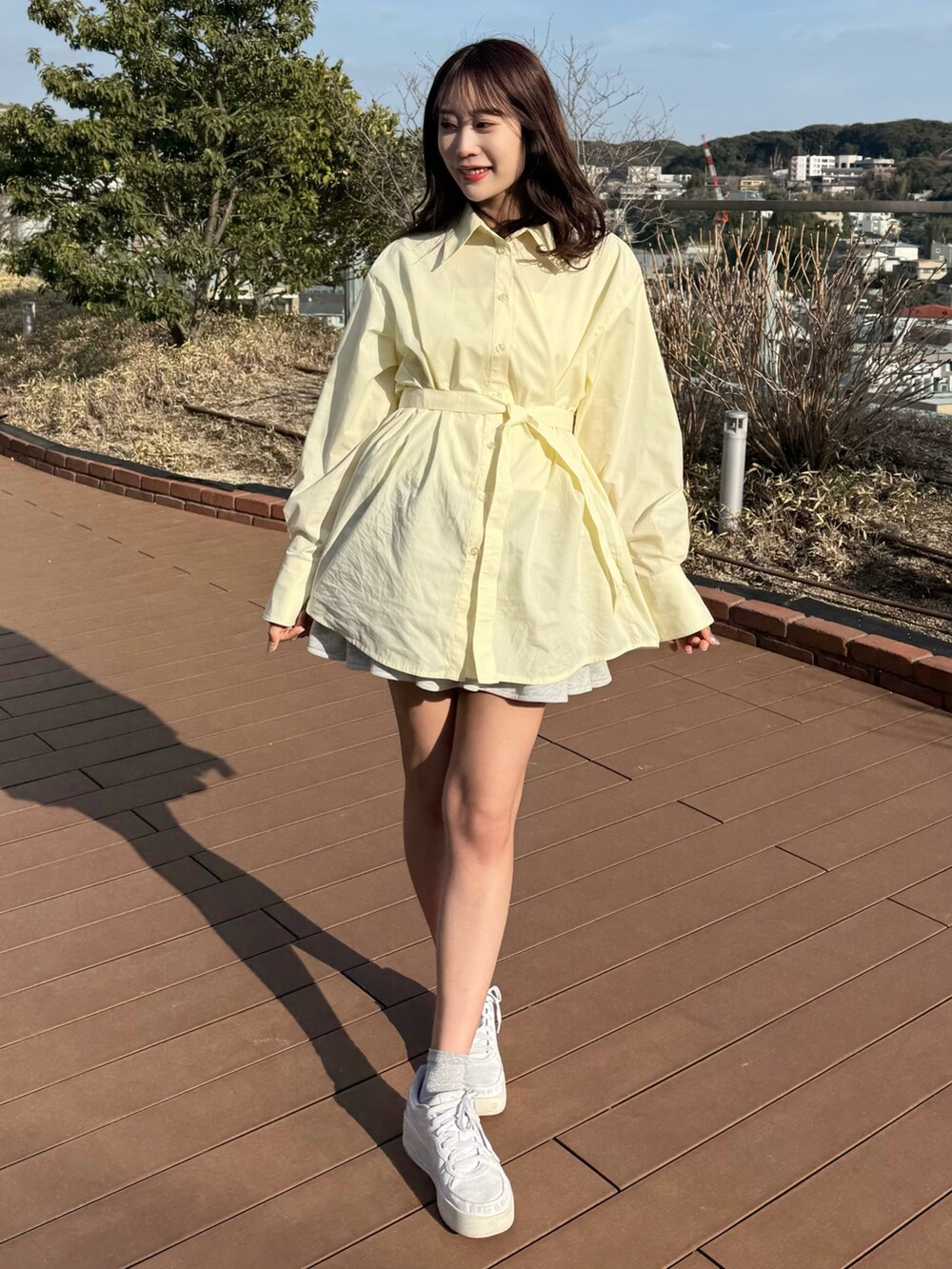 イエロー系のシャツ/ブラウス、グレー系のスカートを着用したレディースの春コーディネートの5枚目の写真