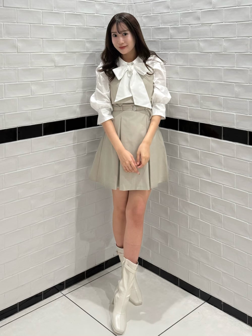 ベージュ系のワンピース、ホワイト系のブーツを着用したレディースの春コーディネートの3枚目の写真