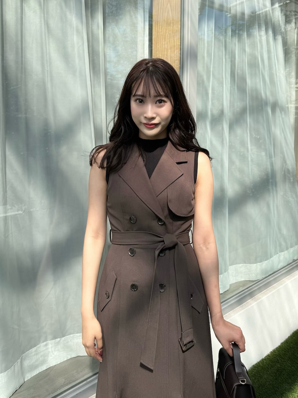 ブラウン系のワンピース、ブラウン系のショルダーバッグ、ブラウン系のパンプスを着用したレディースの秋コーディネートの7枚目の写真