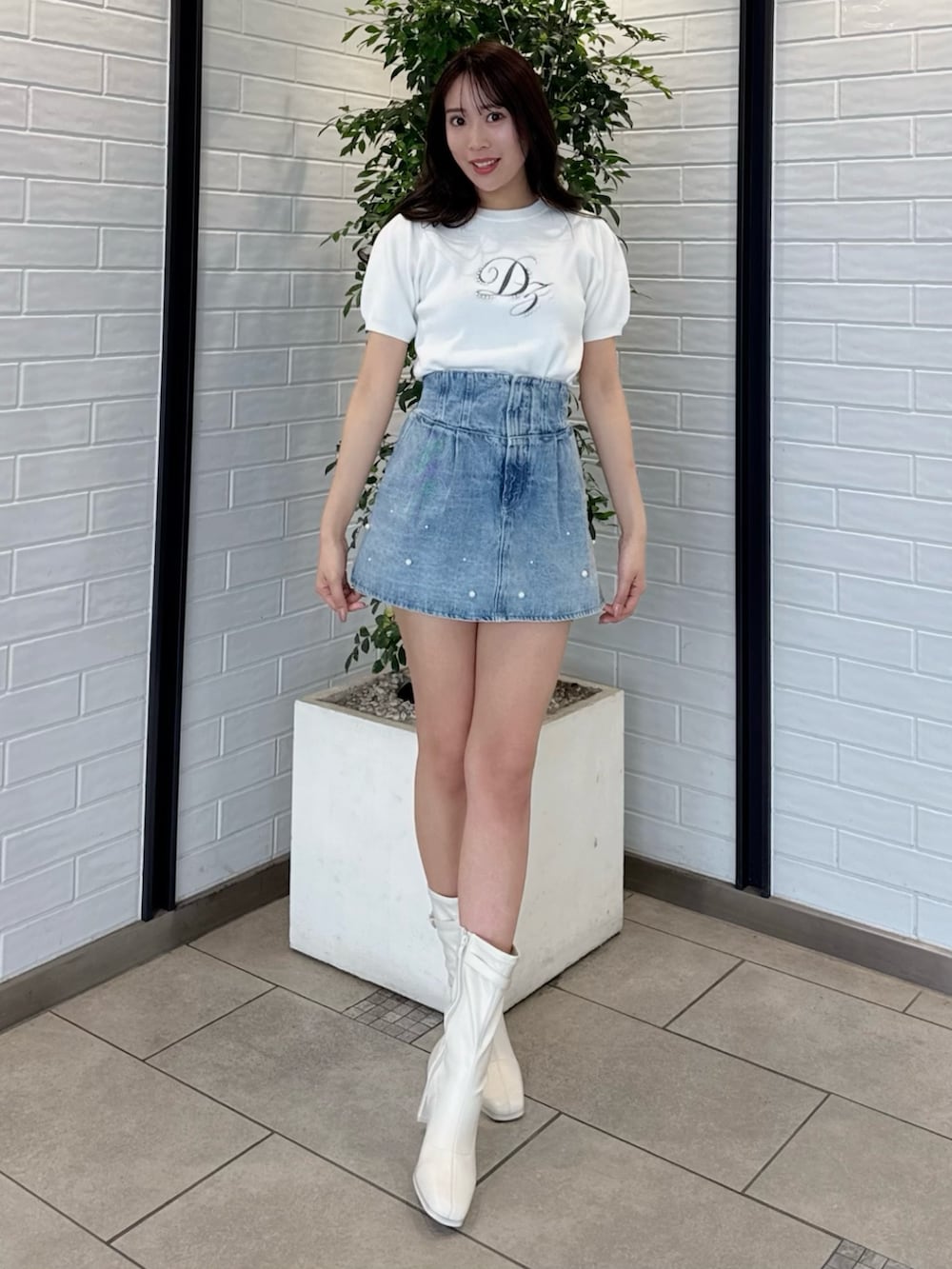 ホワイト系のニット/セーター、ブルー系のデニムパンツ、ホワイト系のブーツを着用したレディースの春コーディネートの6枚目の写真