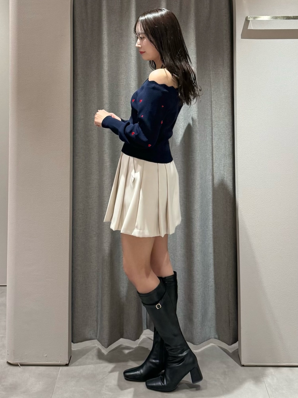 ブルー系のニット/セーター、ホワイト系のスカート、ブラック系のブーツを着用したレディースの冬コーディネートの4枚目の写真