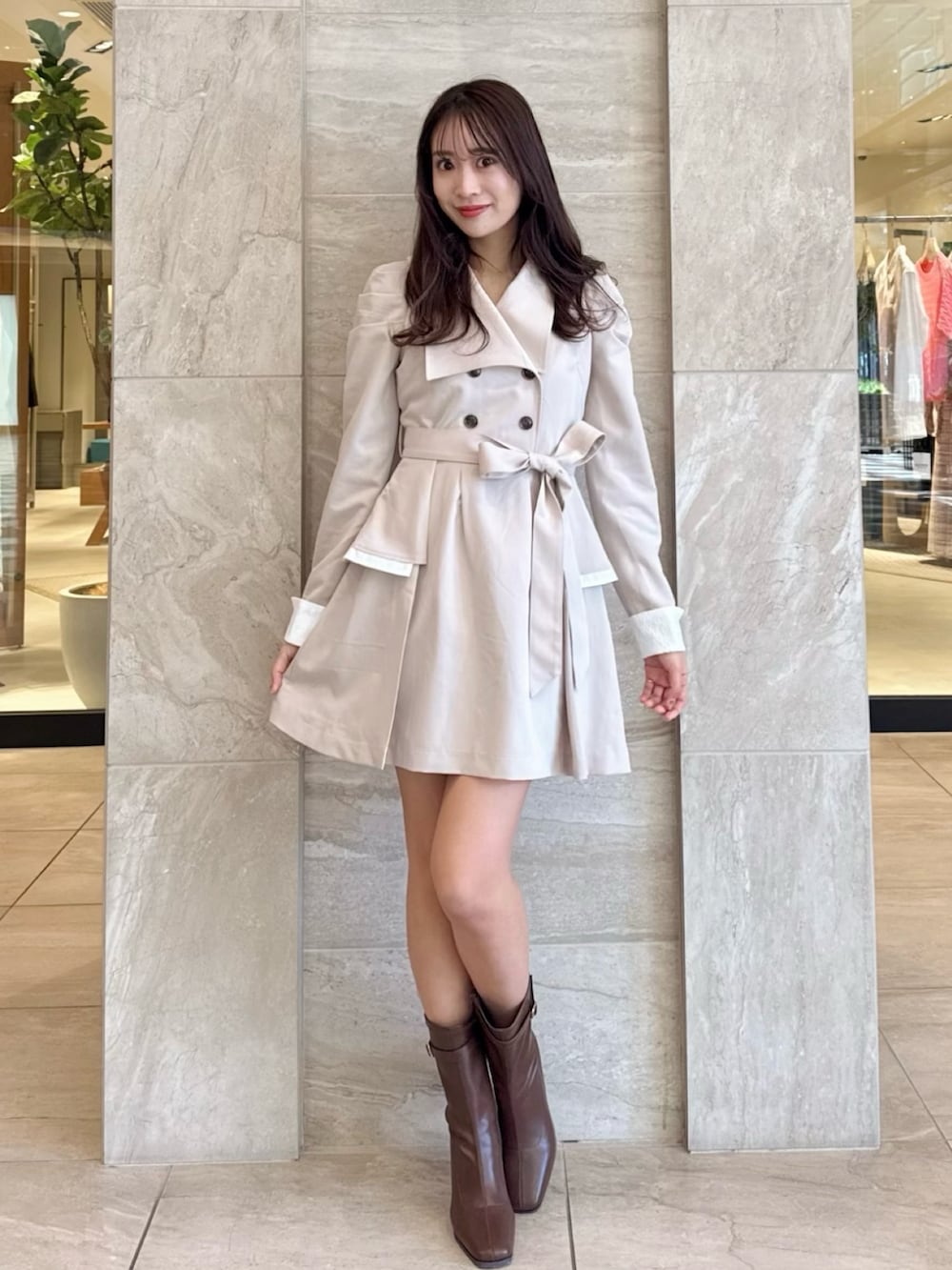 ベージュ系のワンピース、ブラウン系のブーツを着用したレディースの冬コーディネートの2枚目の写真