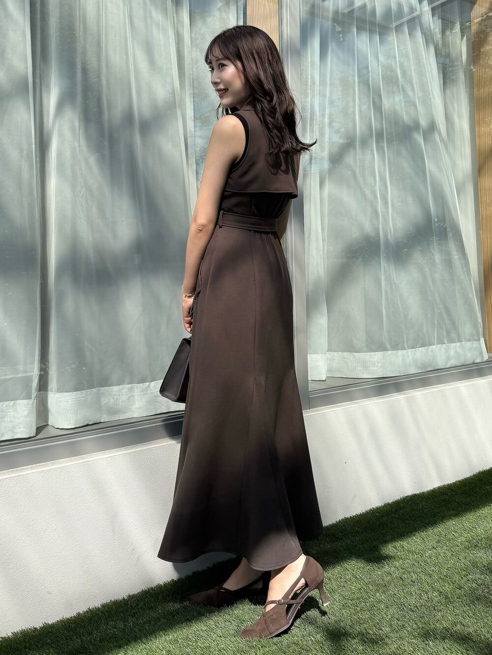 ブラウン系のワンピース、ブラウン系のショルダーバッグ、ブラウン系のパンプスを着用したレディースの秋コーディネートの4枚目の写真