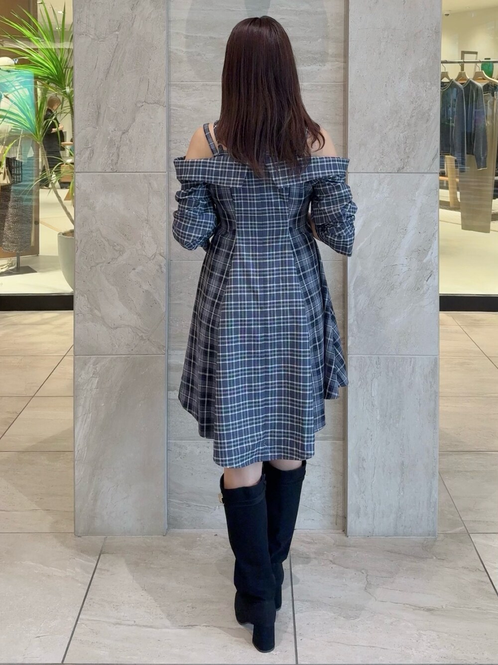 ブルー系のワンピース、ブラック系のブーツを着用したレディースの秋コーディネートの4枚目の写真