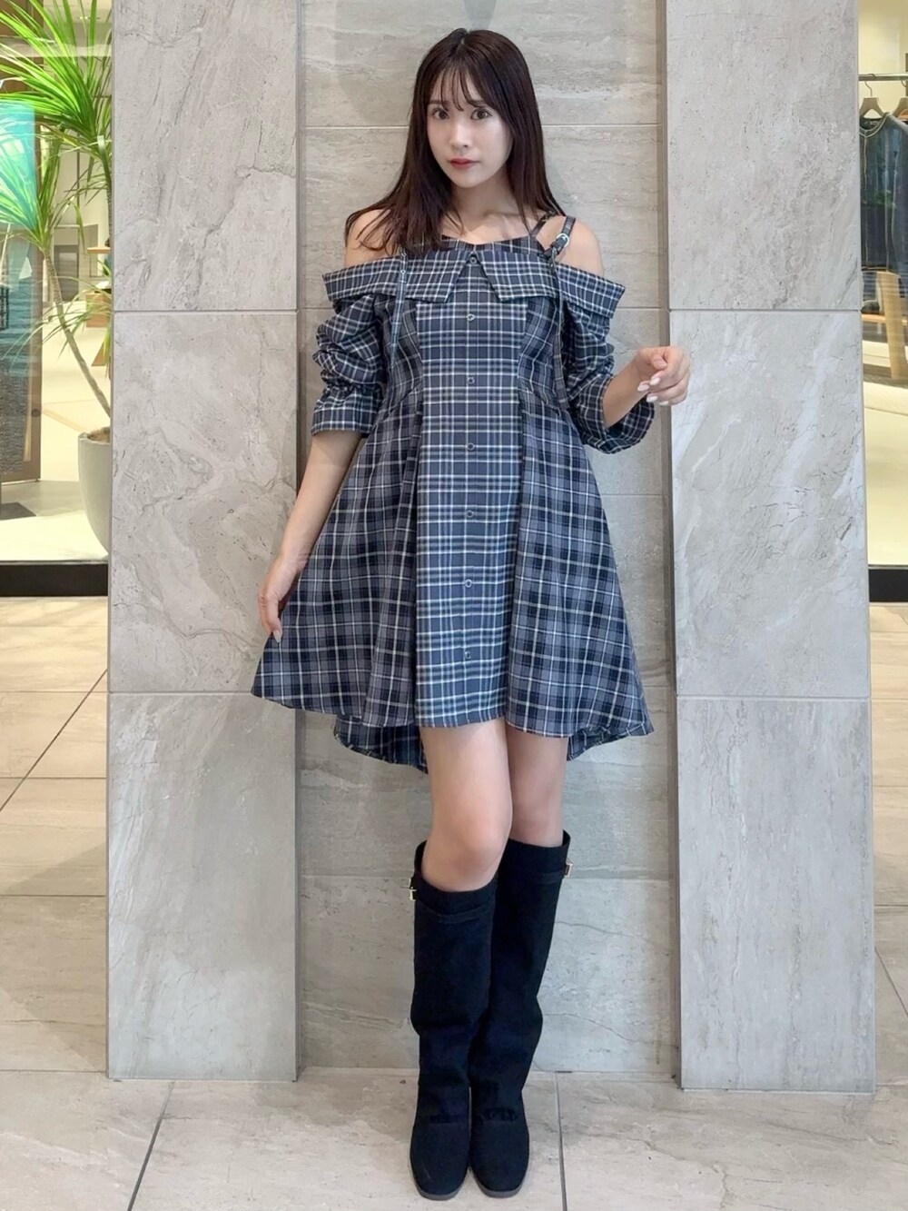 ブルー系のワンピース、ブラック系のブーツを着用したレディースの秋コーディネートの5枚目の写真