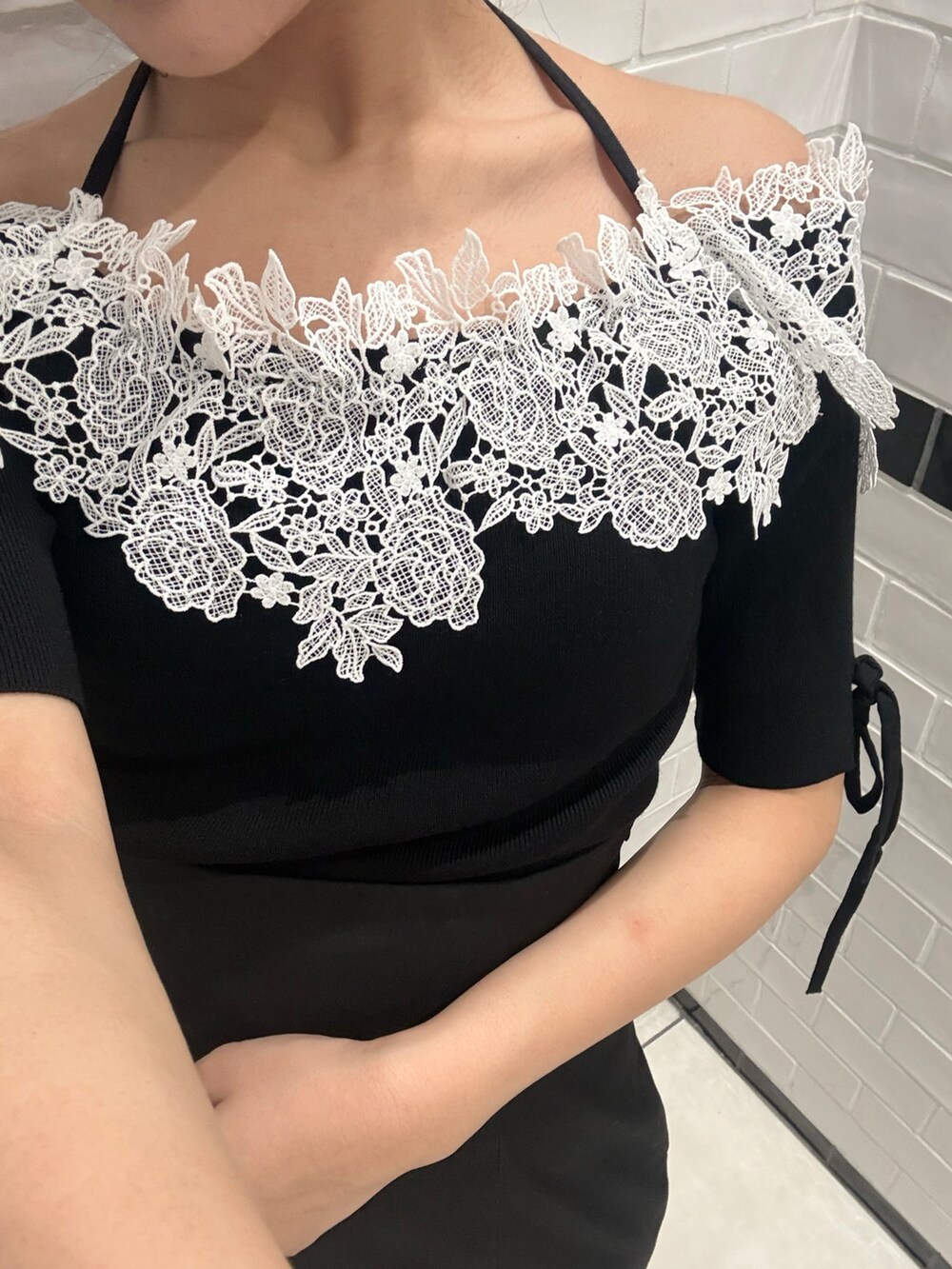 ブラック系のニット/セーター、ブラック系のスカート、ブラック系のパンプスを着用したレディースの春コーディネートの9枚目の写真