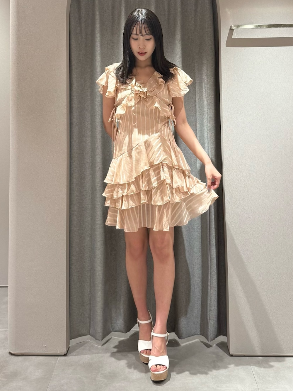 オレンジ系のワンピース、ホワイト系のサンダルを着用したレディースの夏コーディネートの3枚目の写真