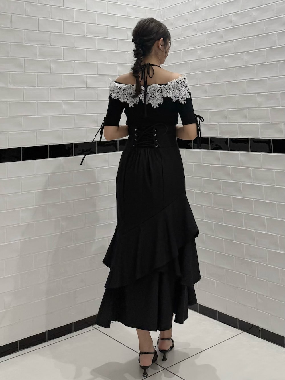 ブラック系のニット/セーター、ブラック系のスカート、ブラック系のパンプスを着用したレディースの春コーディネートの8枚目の写真