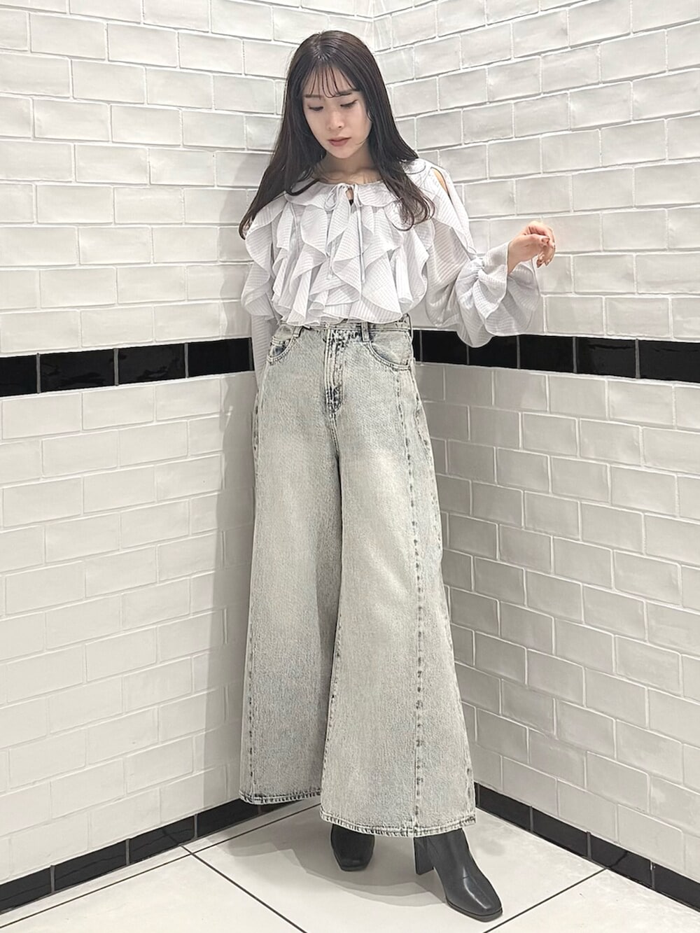 ブラック系のブーツ、グレー系のシャツ/ブラウス、ブルー系のデニムパンツを着用したレディースの春コーディネートの3枚目の写真