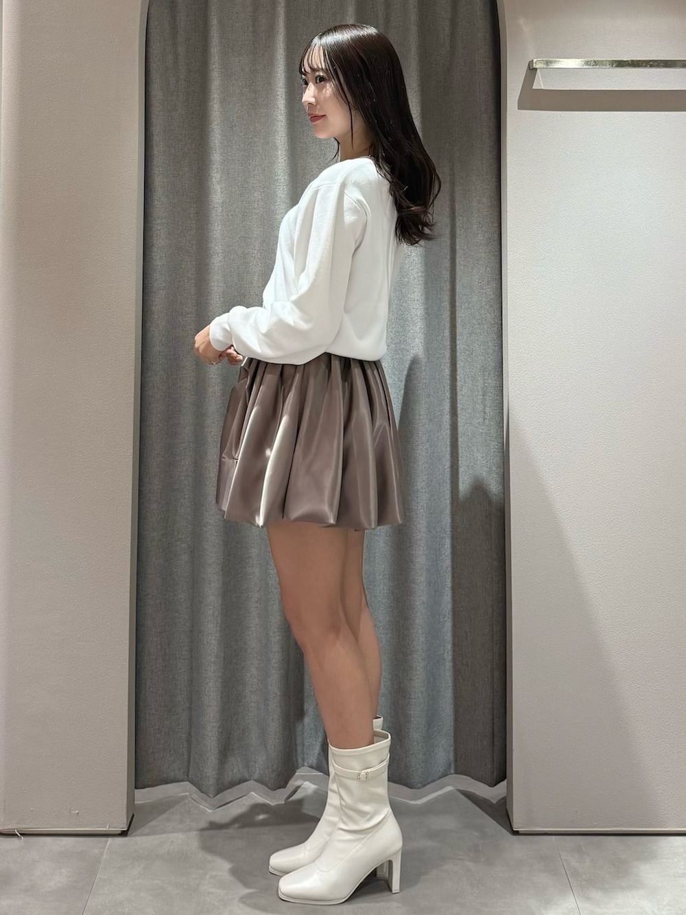 ホワイト系のカーディガン/ボレロ、ブラウン系のスカート、ホワイト系のブーツを着用したレディースの春コーディネートの3枚目の写真