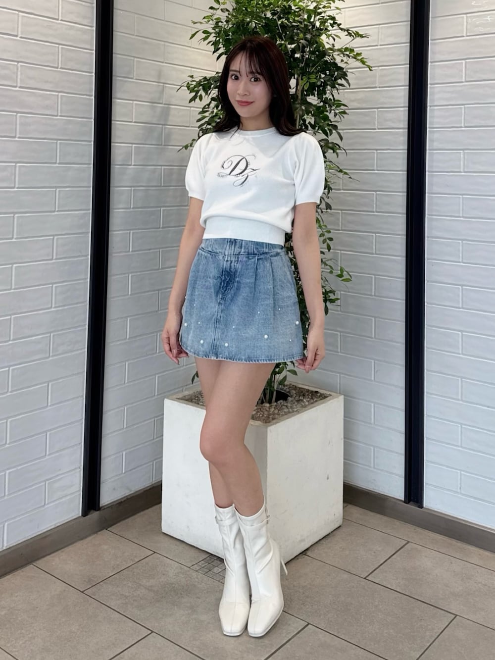 ホワイト系のニット/セーター、ブルー系のデニムパンツ、ホワイト系のブーツを着用したレディースの春コーディネートの3枚目の写真