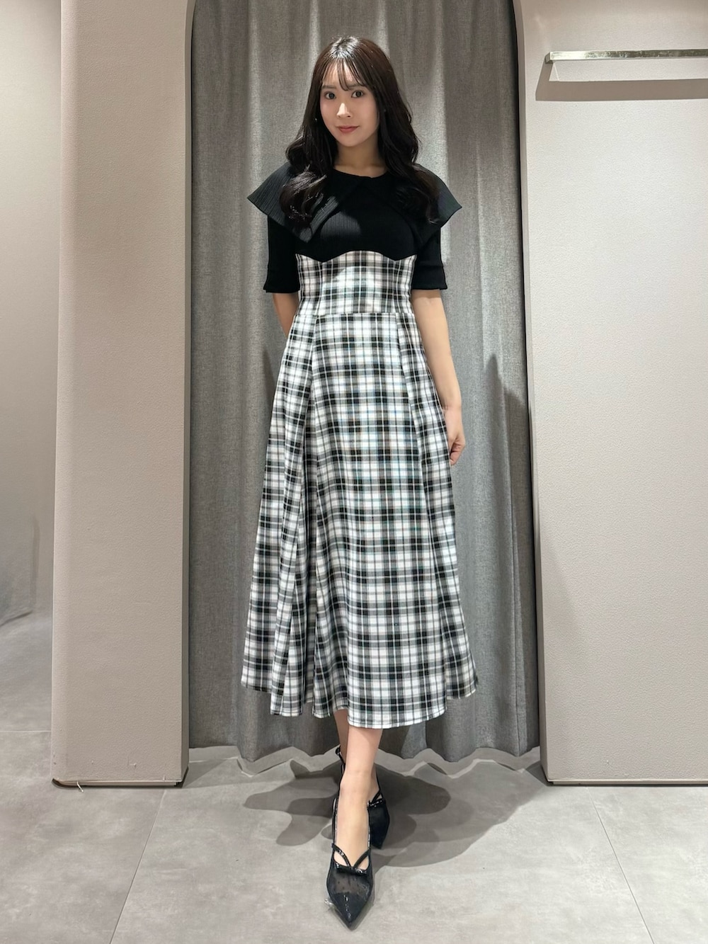 ブラック系のワンピース、ブラック系のパンプスを着用したレディースの春コーディネートの3枚目の写真