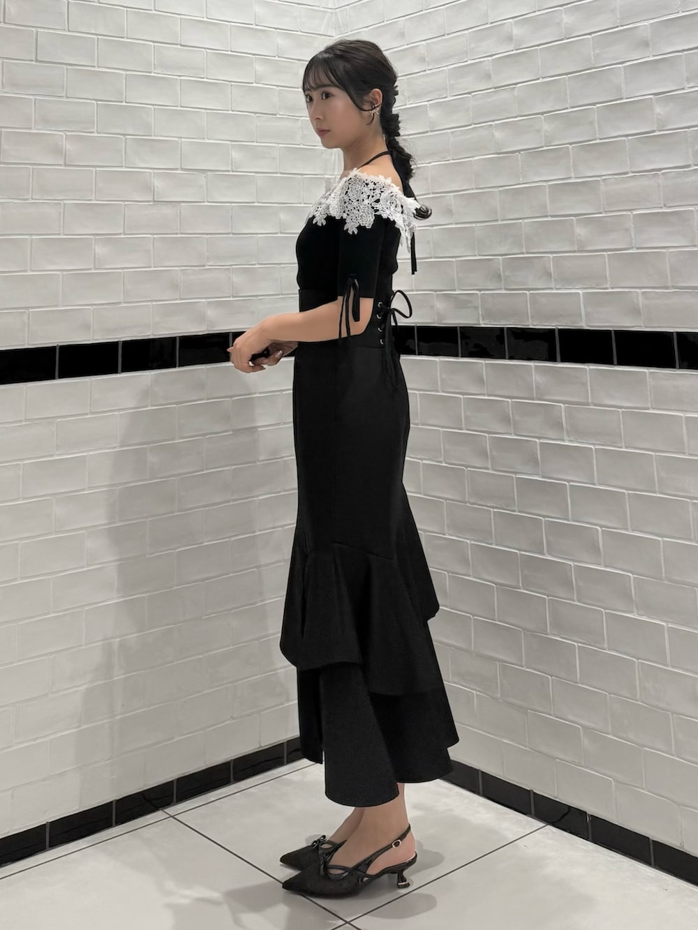 ブラック系のニット/セーター、ブラック系のスカート、ブラック系のパンプスを着用したレディースの春コーディネートの6枚目の写真