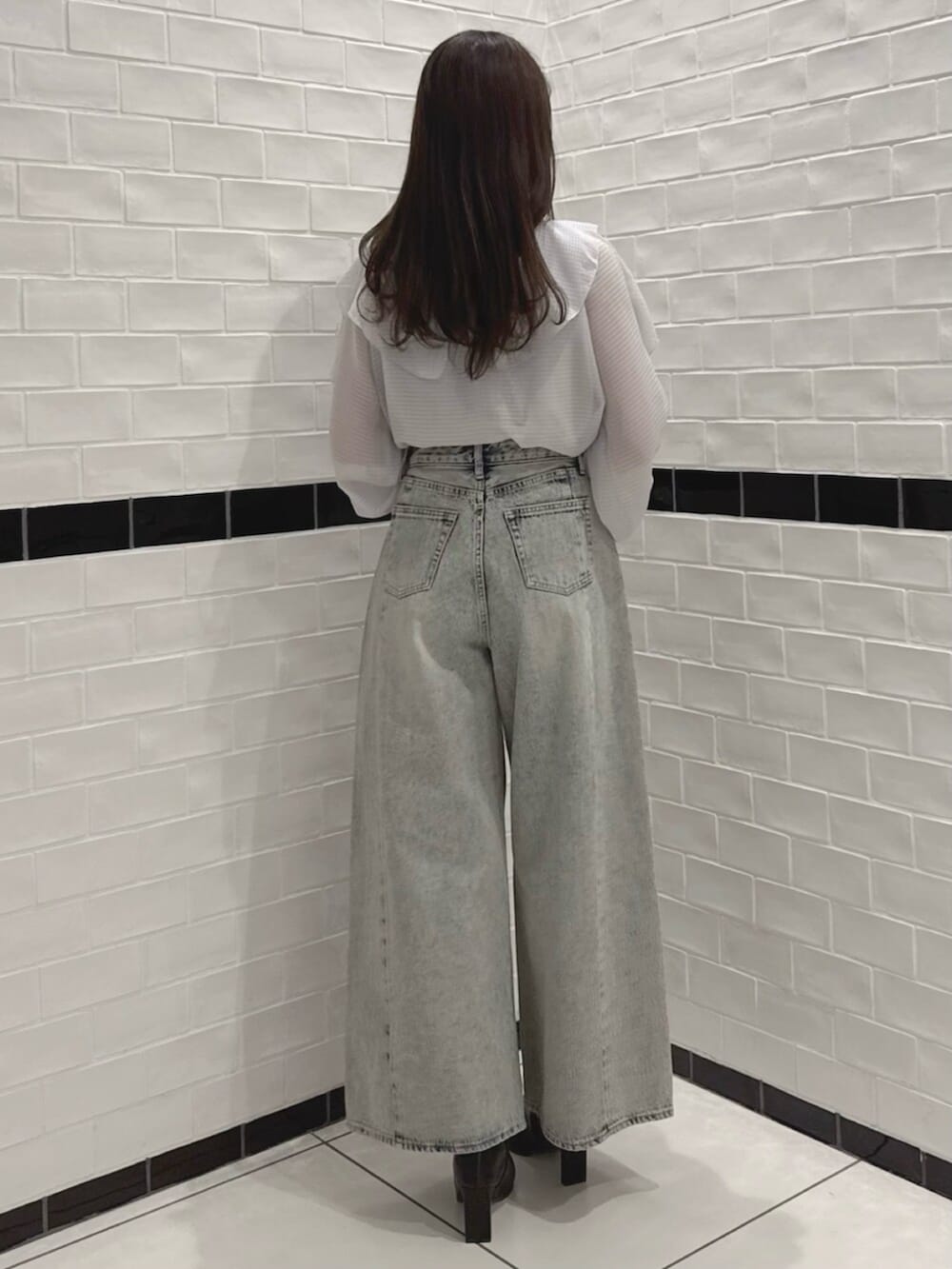 ブラック系のブーツ、グレー系のシャツ/ブラウス、ブルー系のデニムパンツを着用したレディースの春コーディネートの5枚目の写真