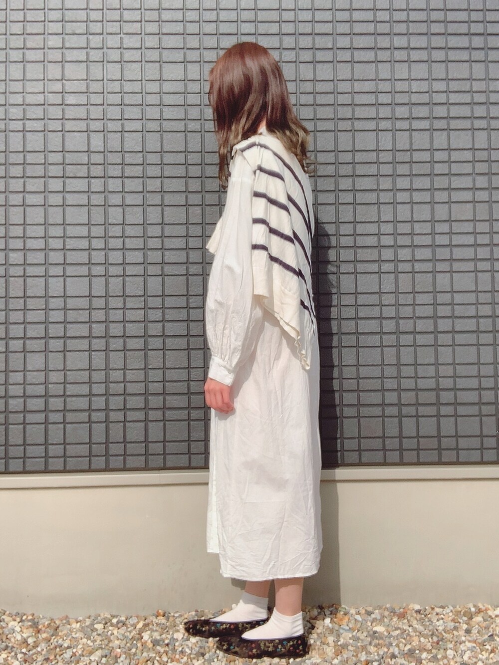 ホワイト系のシャツワンピース、ホワイト系のニット/セーター、ブラック系のシューズを着用したレディースの秋コーディネートの2枚目の写真