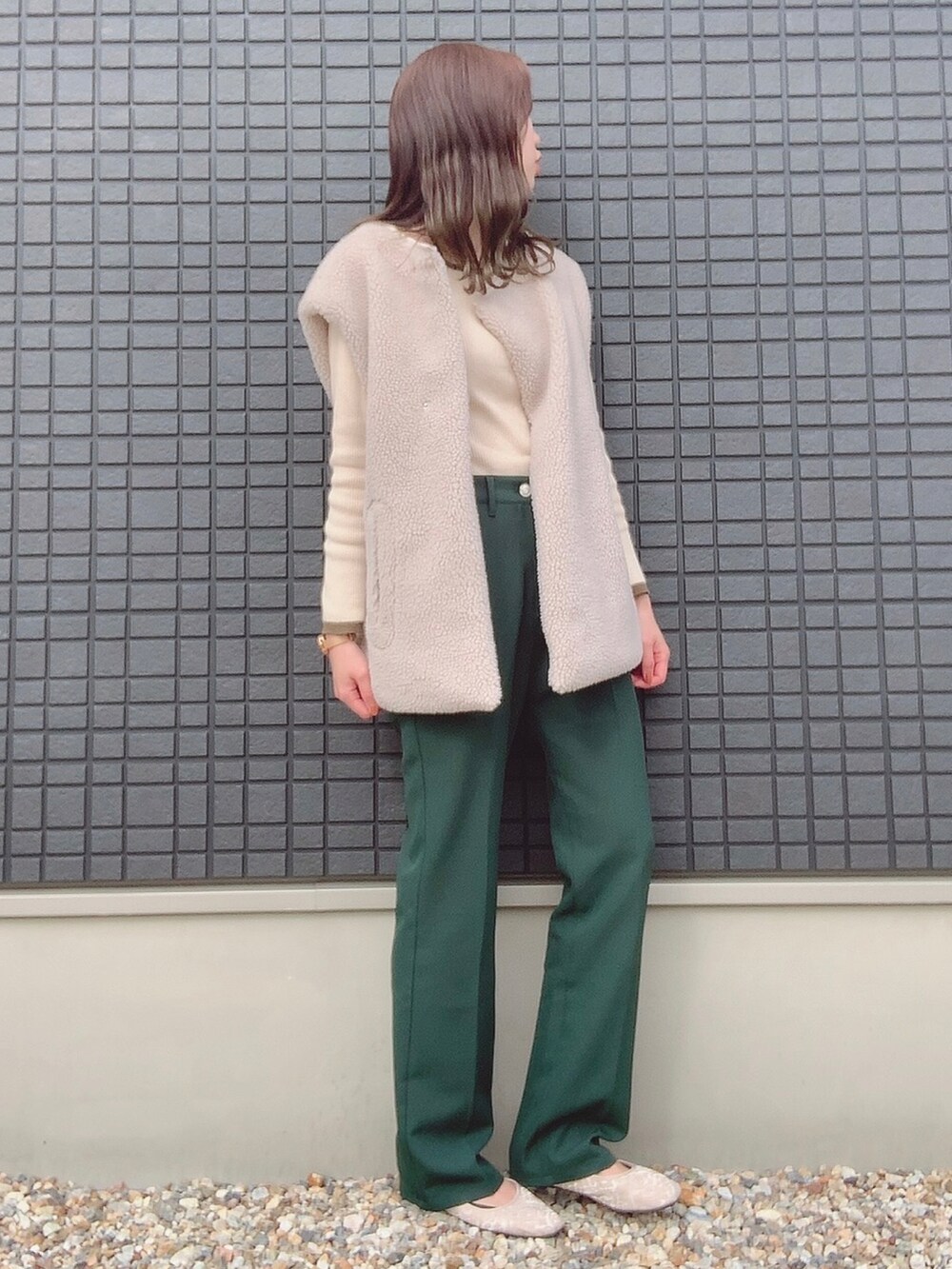ホワイト系のニット/セーター、ホワイト系のその他アウター、グリーン系のスラックスを着用したレディースの秋コーディネートの2枚目の写真