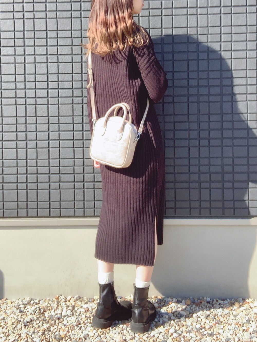 ブラック系のワンピース/ドレス、ベージュ系のショルダーバッグ、ブラック系のブーツを着用したレディースの秋コーディネートの2枚目の写真