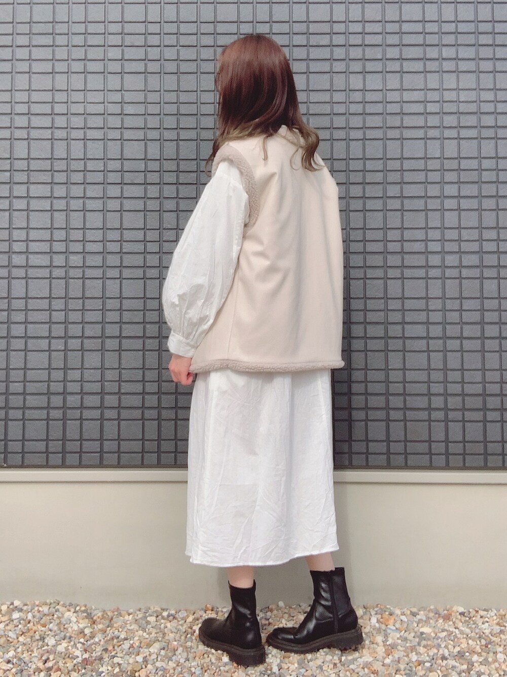 ホワイト系のシャツワンピース、ホワイト系のその他アウター、ブラック系のブーツを着用したレディースの秋コーディネートの2枚目の写真