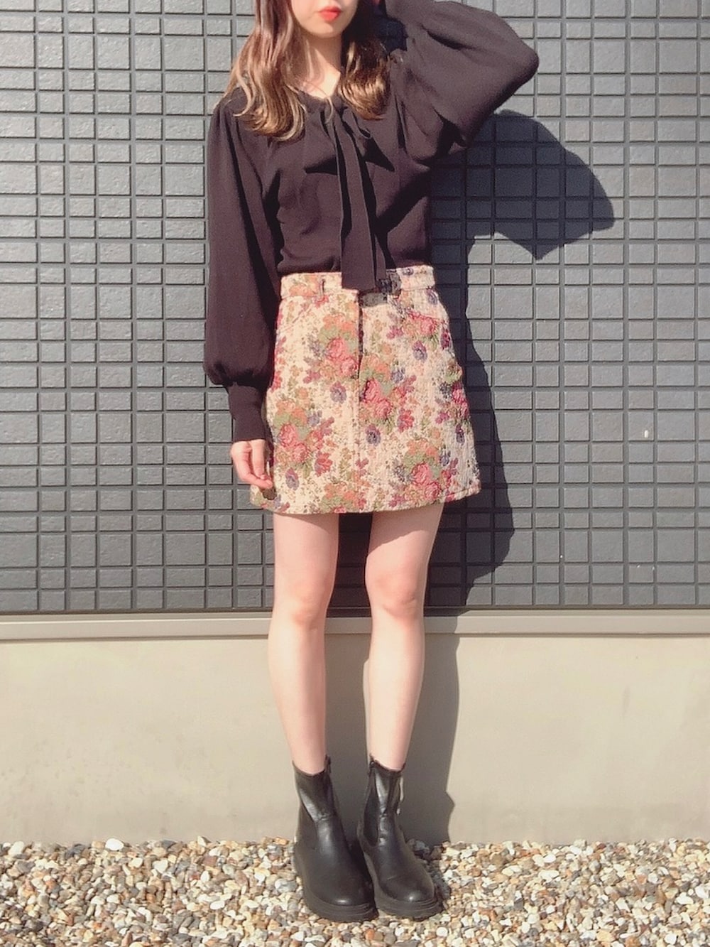 ブラック系のニット/セーター、ベージュ系のスカート、ブラック系のブーツを着用したレディースの冬コーディネートの2枚目の写真