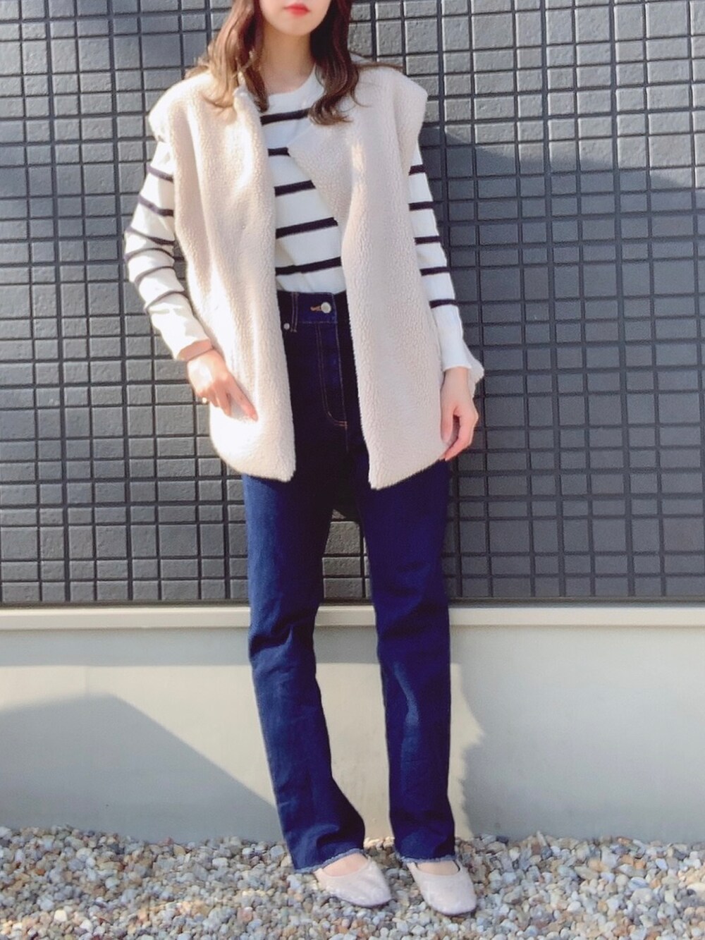 ホワイト系のニット/セーター、ホワイト系のその他アウター、ブルー系のデニムパンツを着用したレディースの秋コーディネートの2枚目の写真