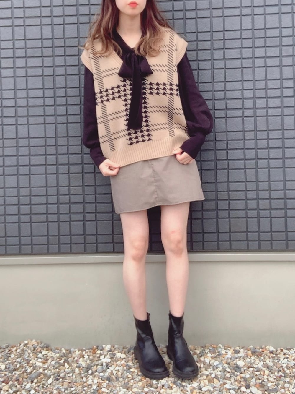 ブラック系のニット/セーター、ベージュ系のベスト、ブラウン系のスカートを着用したレディースの冬コーディネートの2枚目の写真