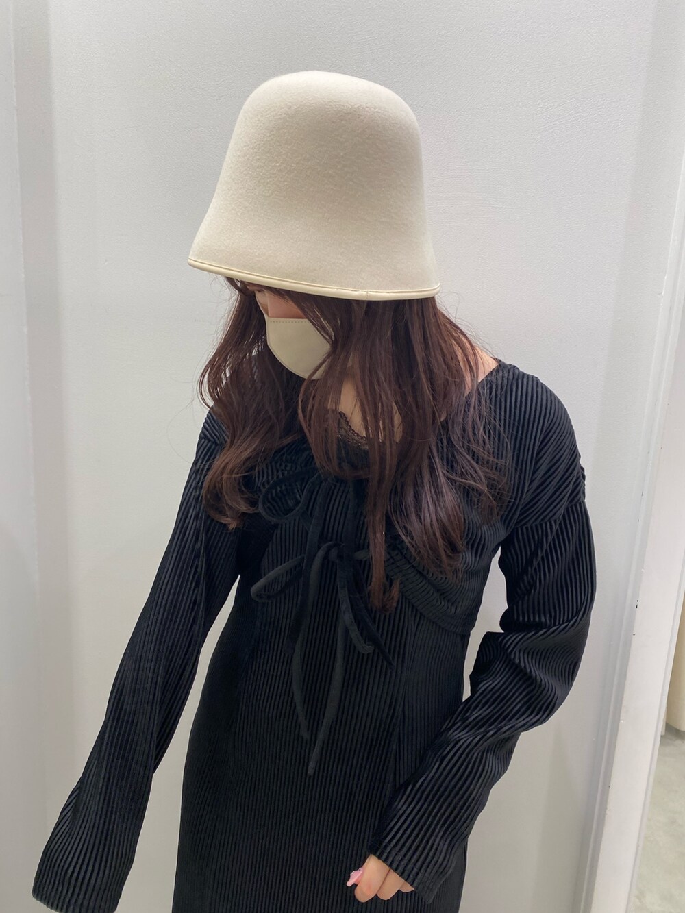 ブラック系のワンピース、ブラック系のブーツ、ホワイト系のハットを着用したレディースの秋コーディネートの3枚目の写真