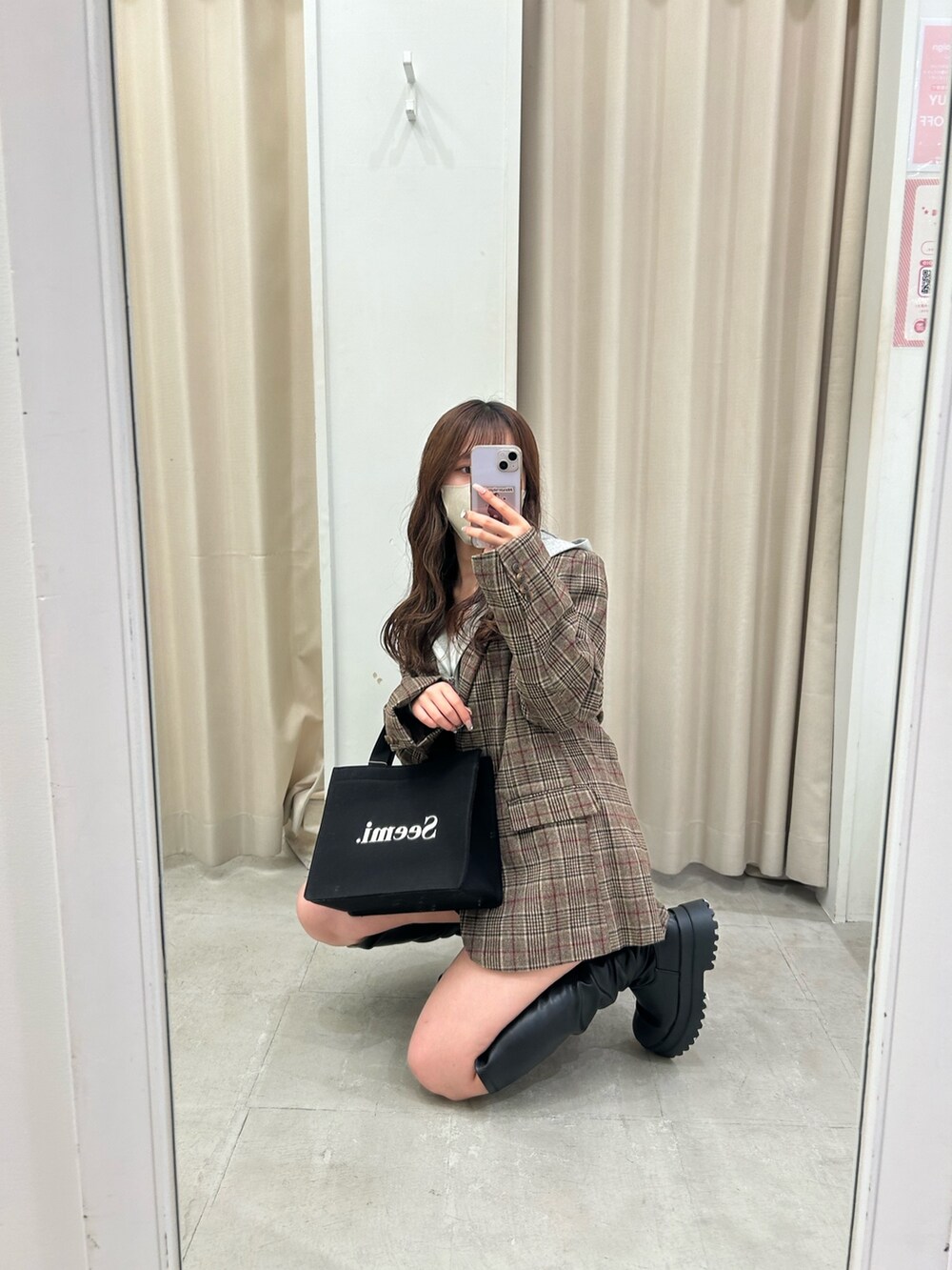 ブラウン系のテーラードジャケット、グレー系のパーカー、ブラック系のスカートを着用したレディースの秋コーディネートの3枚目の写真