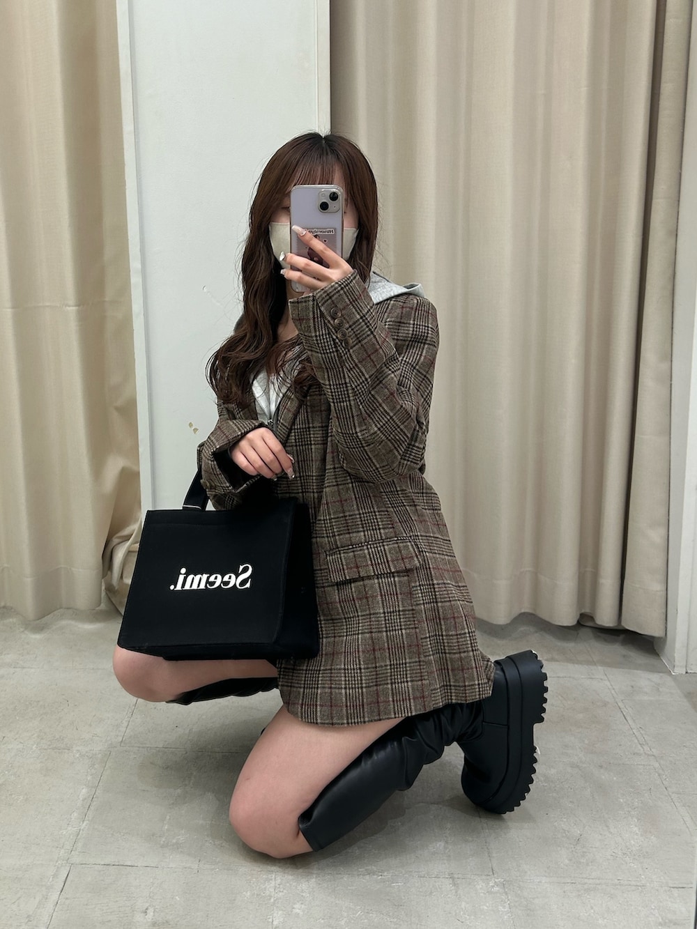 ブラウン系のテーラードジャケット、グレー系のパーカー、ブラック系のスカートを着用したレディースの秋コーディネートの5枚目の写真