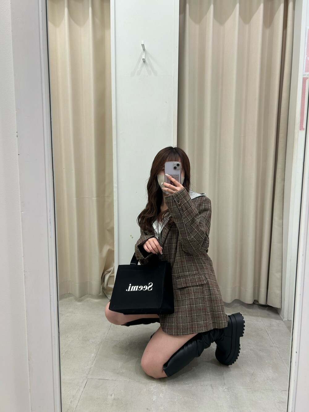 ブラウン系のテーラードジャケット、グレー系のパーカー、ブラック系のスカートを着用したレディースの秋コーディネートの4枚目の写真