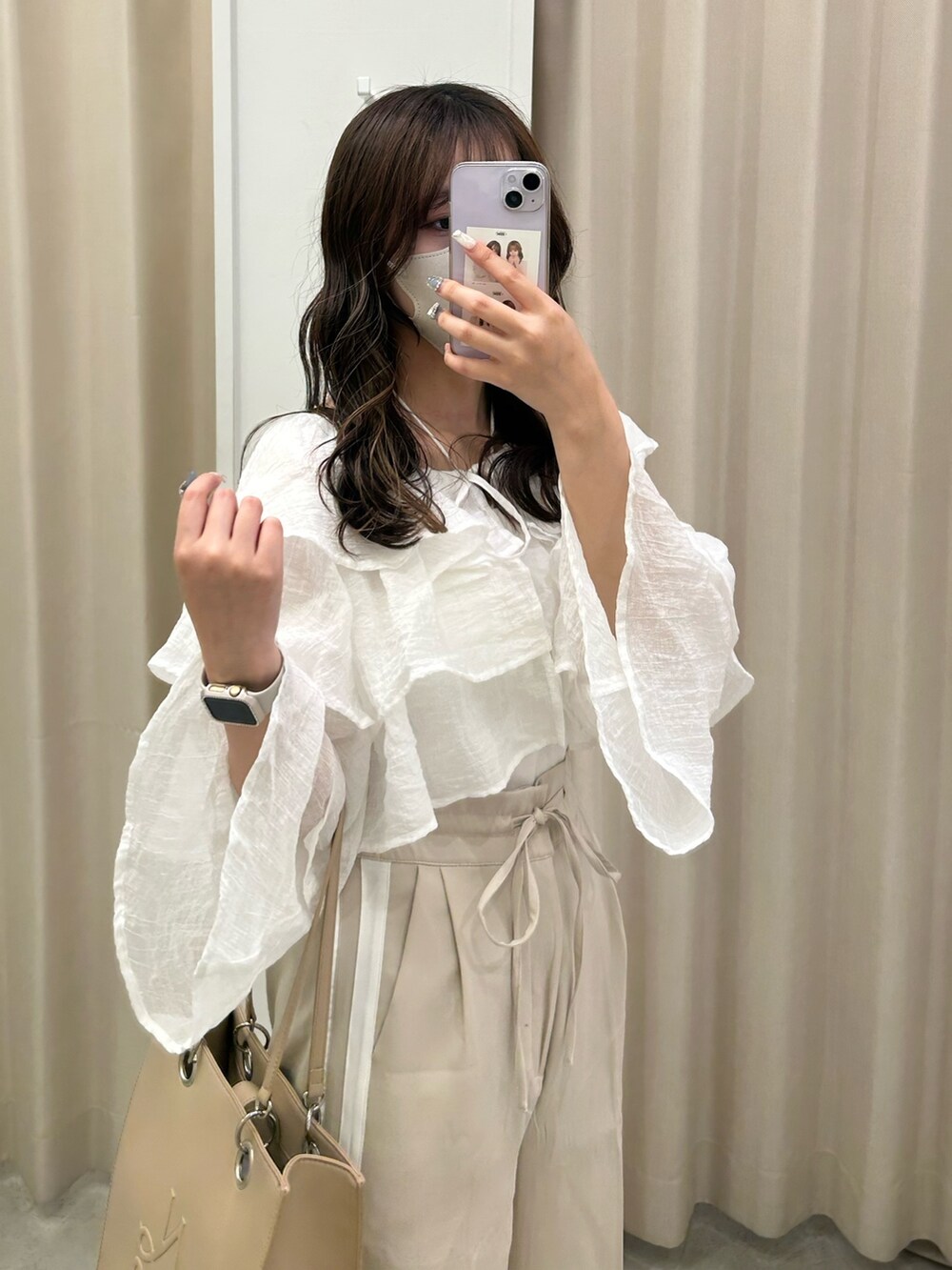ベージュ系のスラックス、ホワイト系のサンダル、ベージュ系のトートバッグを着用したレディースの夏コーディネートの3枚目の写真