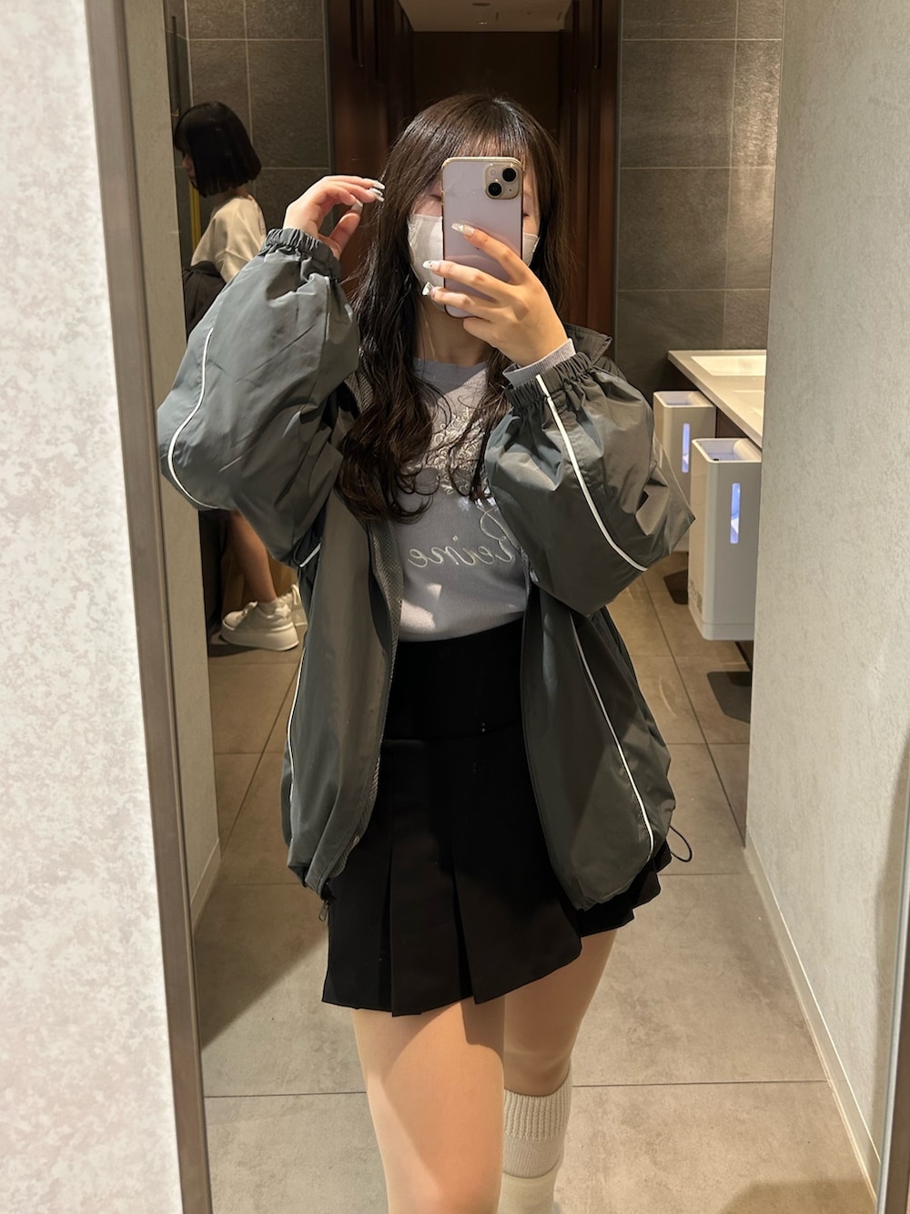 グレー系のナイロンジャケット、ブルー系のニット/セーター、ブラック系のスカートを着用したレディースの冬コーディネートの3枚目の写真