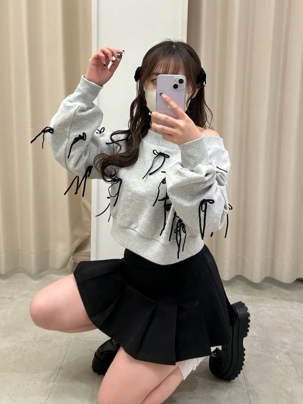 グレー系のスウェット、ブラック系のトートバッグ、ブラック系のスカートを着用したレディースの春コーディネートの2枚目の写真