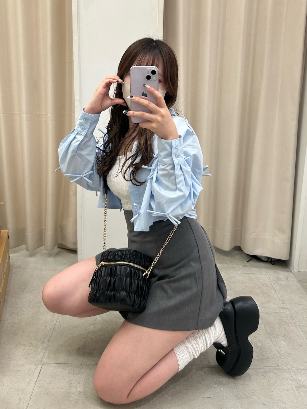 ブルー系のシャツ/ブラウス、グレー系のスカート、ブラック系のショルダーバッグを着用したレディースの春コーディネートの2枚目の写真
